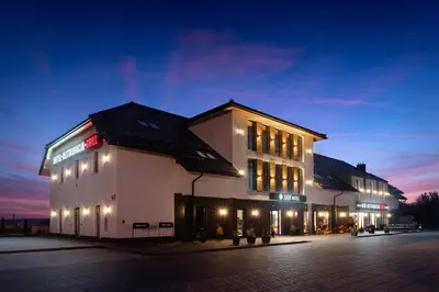 a large white building with lights on it at night at Ilkus Hotel & Restaurant in Krze