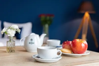 a table with cups and plates of apples and flowers at Ilkus Hotel & Restaurant in Krze