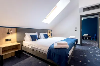 a bedroom with a large bed with blue sheets at Ilkus Hotel & Restaurant in Krze