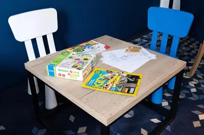 a wooden table with two chairs and books on it at Ilkus Hotel & Restaurant in Krze