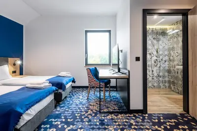 a hotel room with two beds and a desk with a computer at Ilkus Hotel & Restaurant in Krze