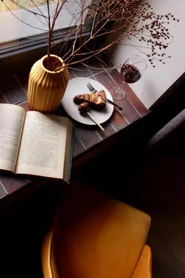 a book and a plate of food on a table at Garden Loft in Roczyny