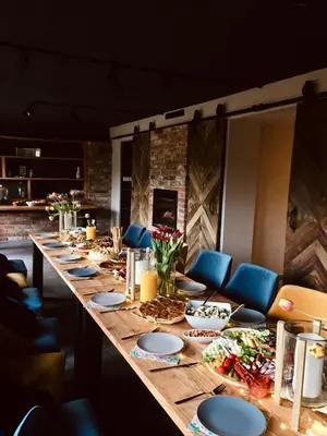 a long table with blue chairs and plates on it at Garden Loft in Roczyny