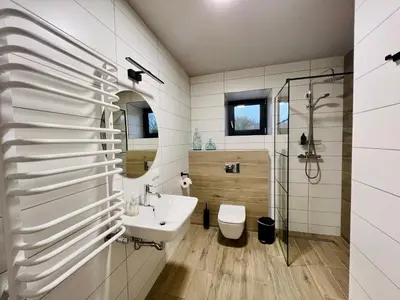 a bathroom with a sink and a toilet and a shower at Garden Loft in Roczyny