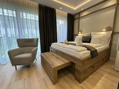 a bedroom with a large bed and a chair at Araliya in Kraków