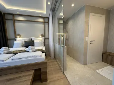 a bedroom with a large bed and a shower at Araliya in Kraków