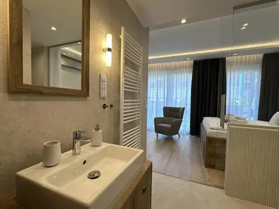a bathroom with a sink and a room with a bedroom at Araliya in Kraków