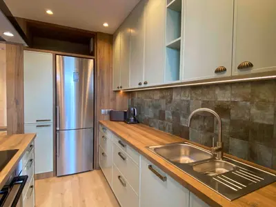 a kitchen with a sink and a refrigerator at Araliya in Kraków