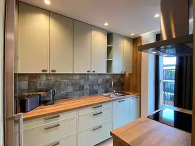 a kitchen with white cabinets and a sink at Araliya in Kraków