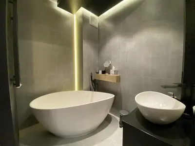 a bathroom with a large white tub and a sink at Araliya in Kraków