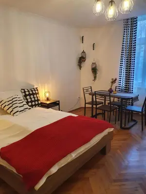 a bedroom with a bed and a table and chairs at Moti Apartments in Kraków