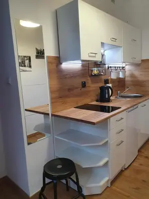 a small kitchen with a counter and a stool at Moti Apartments in Kraków