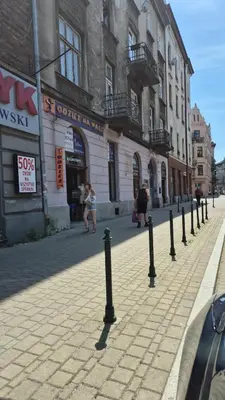 a street with a row of black poles on the sidewalk at Moti Apartments in Kraków