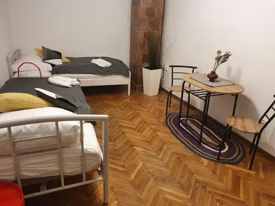 a room with two beds and a wooden floor at Moti Apartments in Kraków