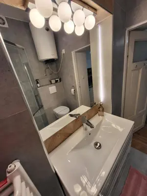 a bathroom with a sink and a mirror at Moti Apartments in Kraków