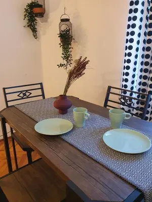 a wooden table with two plates and a vase on it at Moti Apartments in Kraków