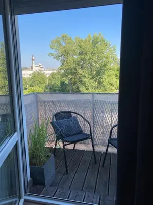 two chairs sitting on a deck with a window at Let’s Dream Apartment 68 m2 in Kraków