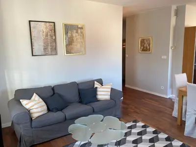 a living room with a blue couch and a table at Let’s Dream Apartment 68 m2 in Kraków