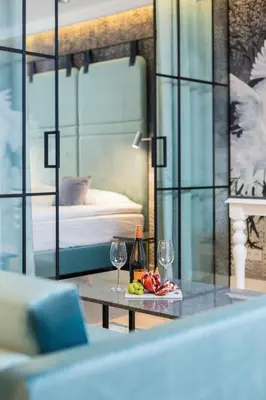 a room with a bed and a table with wine glasses at Riva Verona Apartment by Renters Prestige in Kraków