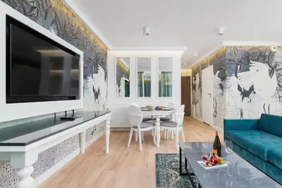 a living room with a blue couch and a tv at Riva Verona Apartment by Renters Prestige in Kraków
