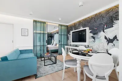a living room with a blue couch and a tv at Riva Verona Apartment by Renters Prestige in Kraków