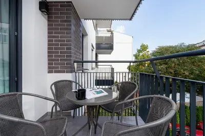 a patio with chairs and a table on a balcony at Riva Verona Apartment by Renters Prestige in Kraków