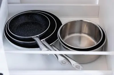 two pans and a pot in a drawer at Riva Verona Apartment by Renters Prestige in Kraków