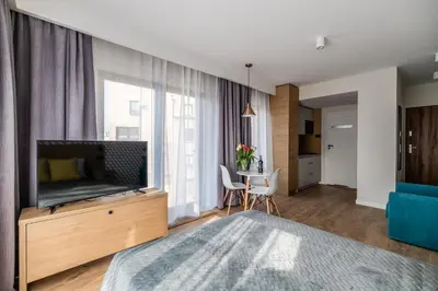 a bedroom with a large bed and a television at Krakow Square Residence in Kraków