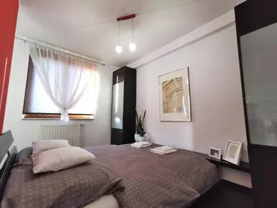 a bedroom with a bed with two pillows and a window at Apartament 33 in Kraków