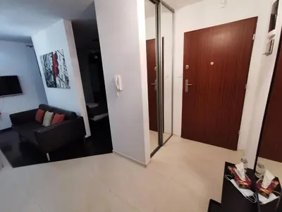 a living room with a black chair and a door at Apartament 33 in Kraków