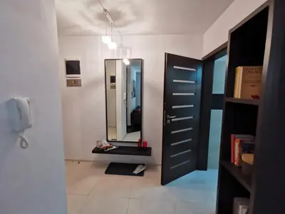 a bathroom with a mirror and a black door at Apartament 33 in Kraków