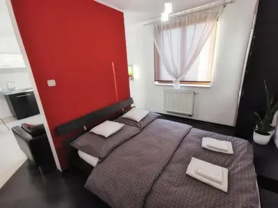 a bedroom with two beds and a red wall at Apartament 33 in Kraków