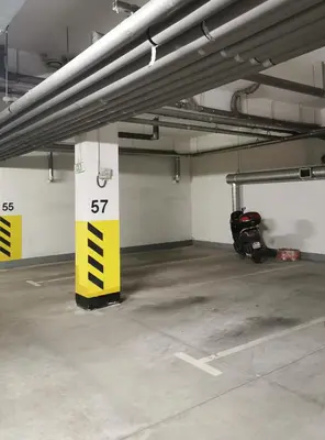 a parking garage with a parking lot sign and a scooter at Apartament 33 in Kraków