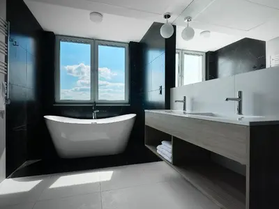 a bathroom with a tub and two sinks and a window at Tennis & Country Club Hotel in Giebułtów