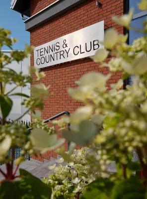 a sign on the side of a brick building at Tennis & Country Club Hotel in Giebułtów