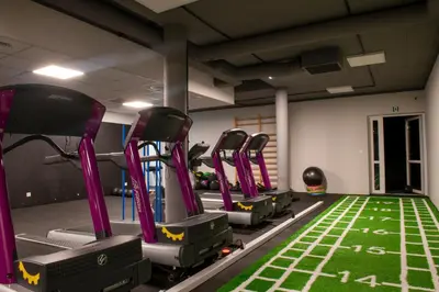 a gym with rows of exercise bikes in a room at Tennis & Country Club Hotel in Giebułtów