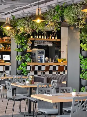 a restaurant with tables and chairs and potted plants at Tennis & Country Club Hotel in Giebułtów