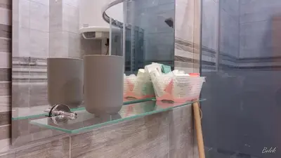 a glass shelf in a bathroom with toiletries on it at Mieszkanko na peryferiach in Chrzanów