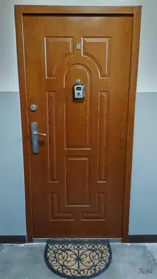 a large wooden door with a mat in front of it at Mieszkanko na peryferiach in Chrzanów