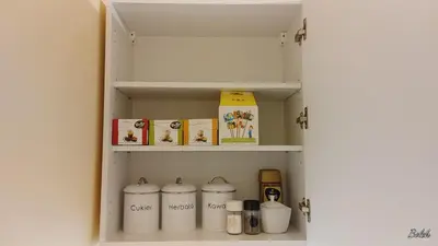 a cupboard with four white containers in it at Mieszkanko na peryferiach in Chrzanów