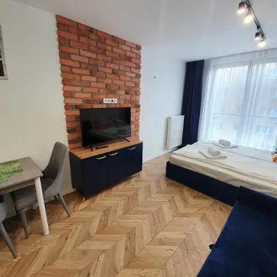 a room with a bed and a brick wall at Ice Apartments in Kraków