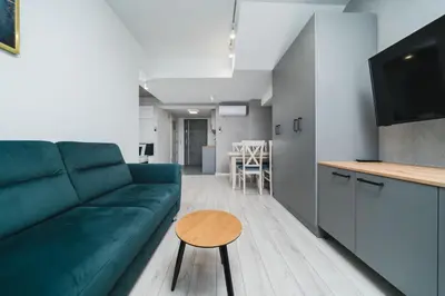 a living room with a green couch and a table at Ice Apartments in Kraków