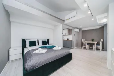 a bedroom with a bed and a dining room at Ice Apartments in Kraków