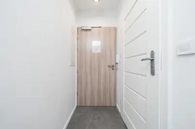 a corridor with a door and a hallway at Ice Apartments in Kraków
