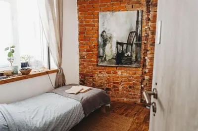 a bedroom with a brick wall and a bed at Kieszonka dla singla in Kraków