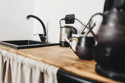 a kitchen counter with a sink and utensils at Kieszonka dla singla in Kraków
