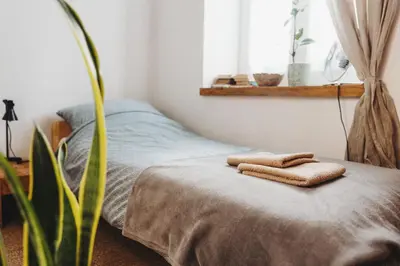 a bedroom with a bed with two towels on it at Kieszonka dla singla in Kraków