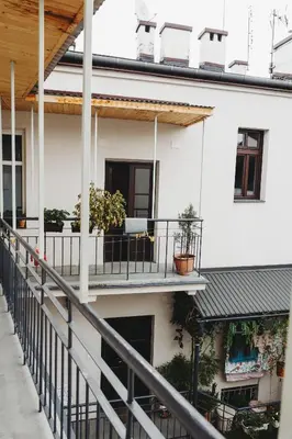 a white house with a balcony with potted plants at Kieszonka dla singla in Kraków