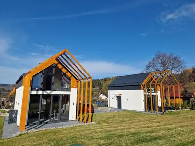 two houses being built on a grass field at Zawobaja in Zawoja