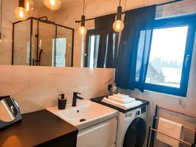 a bathroom with a sink and a washing machine at Zawobaja in Zawoja
